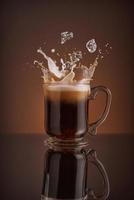 Splash de bebida de café de hielo sobre un fondo marrón. foto