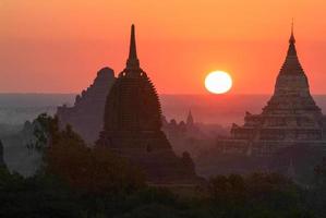 Silhouettes of ancient Buddhist Temples by sunrise at Bagan photo