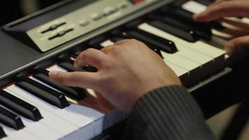 Musician playing keys of synthesizer keyboard  fingers hands close up video