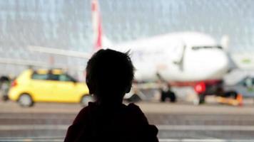 liten pojke som tittar på flygplan på flygplatsen