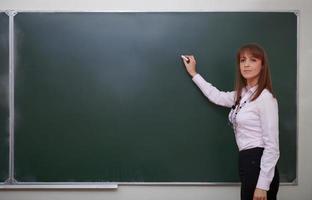 Back to school. Portrait of teacher with chalk. photo