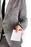 Man in gray business suit holds blank white card photo