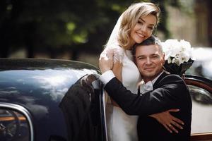 Groom holds bride in his arms photo