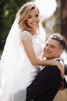 Bride and groom embrace in the sunshine photo