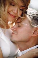 Bride and groom embrace in the sunshine photo