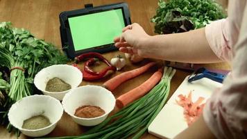 de vrouw kookt eten met behulp van tablet video