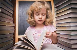 Portrait of cute smart girl reading a book photo