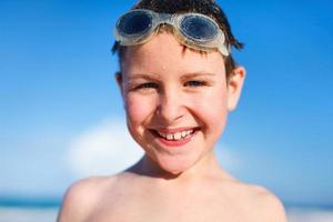 Happy boy in goggles at beach photo