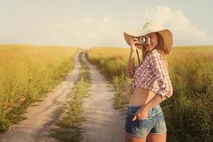 hermosa chica con cámara retro sobre camino rural, instagra