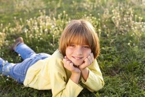 Smiling young boy lying on grass photo