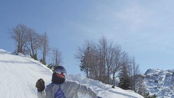 Zeitlupe aus der Nähe: Snowboarder springt über die Kamera im Snowpark an einem schönen sonnigen Tag im schneebedeckten Skigebiet video