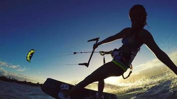 mooi meisje plezier zomer extreme watersporten kitesurfen in bikini. slow motion. video