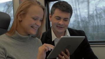 Young people working with pad and talking in the train