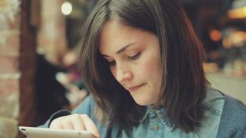 bela jovem usando tablet digital touchscreen em um café