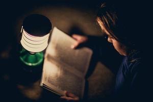 Girl reading book in lighting lamp