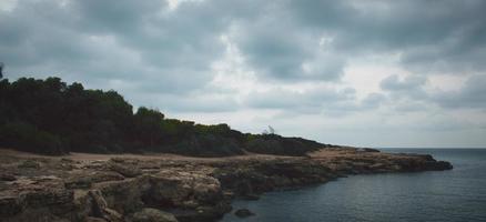 Clouds over a rocky seashore photo