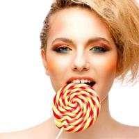 woman licks candy with beautiful make-up isolated on white background