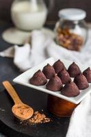 chocolate truffles, cocoa powder in a wooden spoon photo