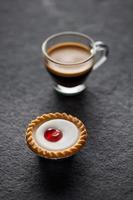 Small cherry cake with a glass of fresh espresso