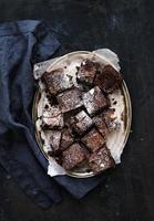 Dark chocolate and walnut brownie squares on a silver tray photo