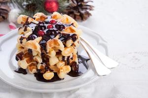 Waffles with chocolate sauce and winter berries for christmas photo