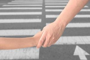 Adult holding child's hand isolated on background photo