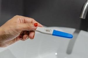 Person holding pregnancy test photo