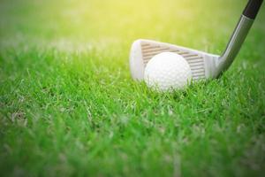 Close-up of a golf ball on green grass in golf course photo