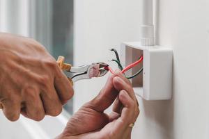 Electrician installs electrical outlet