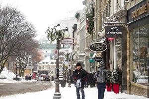 Quebec, Canada, 2020 - People walking in snow near shops photo