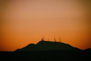 silueta de montaña con puesta de sol naranja foto