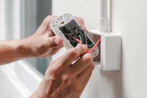 Electrician installs electrical outlet photo