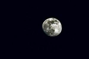 Nearly full moon on black sky photo