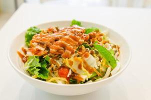 Bowl of chicken salad on table photo