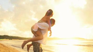 Joven pareja romántica se divierte al atardecer en la orilla en verano al aire libre - imágenes de video de gimbal steadicam hd