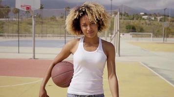una joven atleta caminando con baloncesto