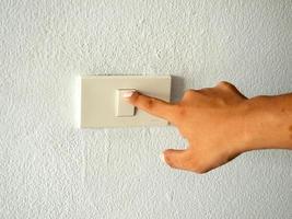hand with finger on light switch photo