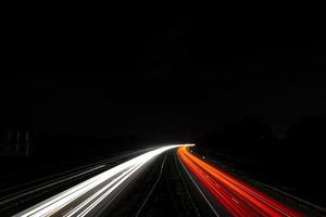 lapso de tiempo de las luces del coche en la carretera por la noche foto