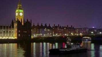 Zoom-out, time-lapse del Big Ben por la noche al otro lado del Támesis
