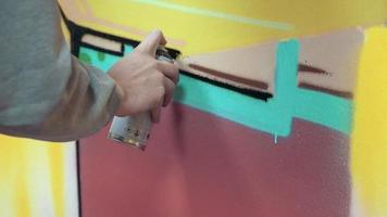grafiteiro pintando na parede, interior, close-up video