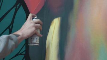 Artista de graffiti pintando en la pared, interior, cerrar
