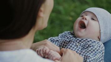 Happy baby boy playing with mother in the park video