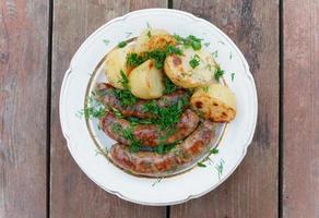 Grilled sausages and potatoes photo