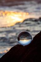 Bola de cristal sobre una roca durante la puesta de sol foto