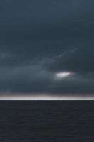 Silhouette of land and cloudy sky photo