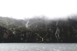 Waterfalls on a mountainside and a lake photo