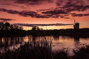 Silhouette of buildings near body of water at sunset photo