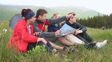 vrienden op een kampeertrip samen lachen en kaart lezen video