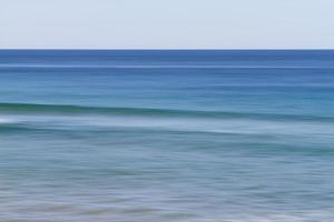 Long-exposure of ocean waves during the day photo