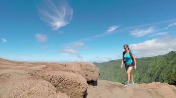 aktiv ung kvinna som går på stig längs bergskanten med fantastisk utsikt